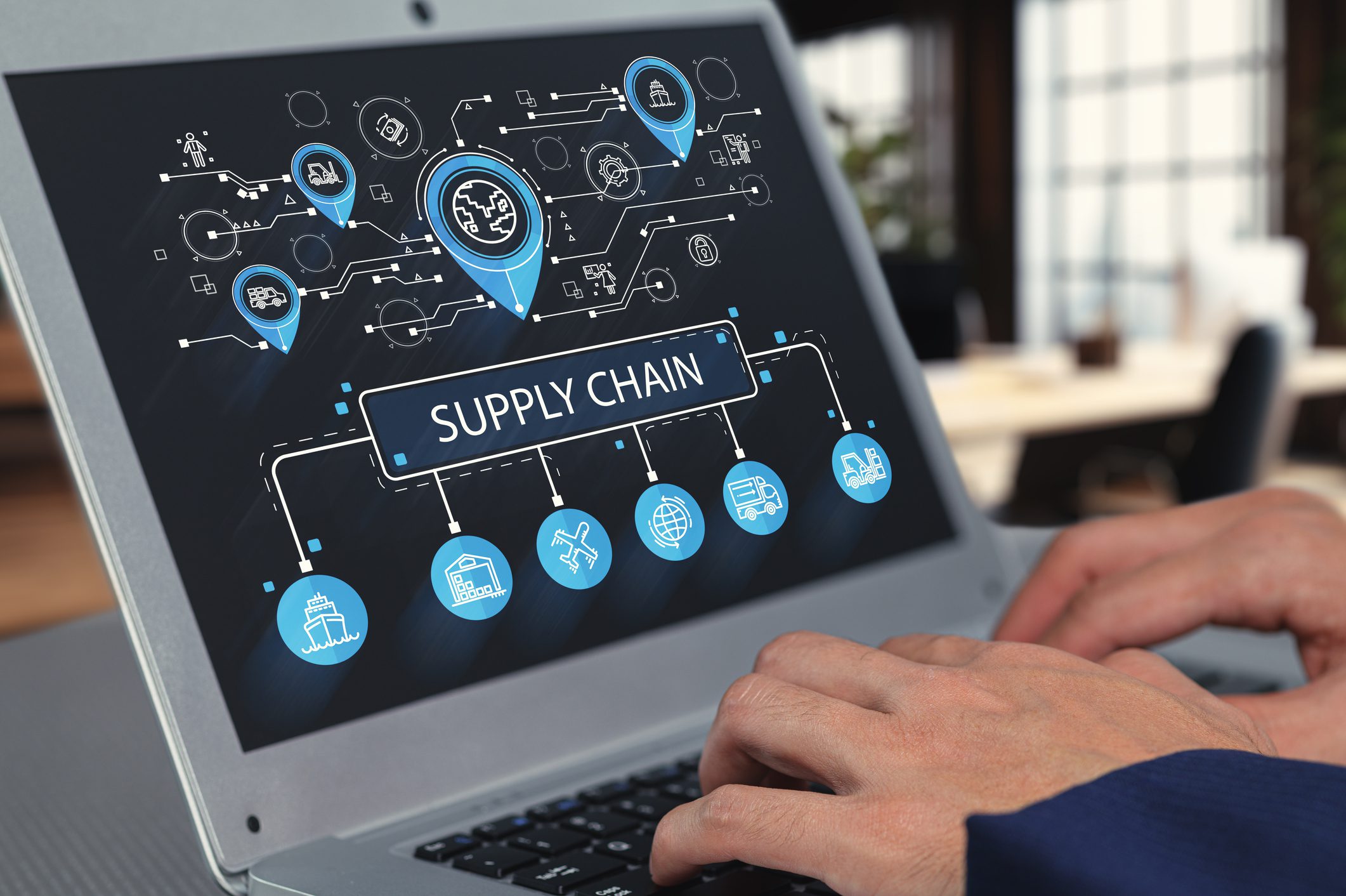 Hands typing on supply chain diagram